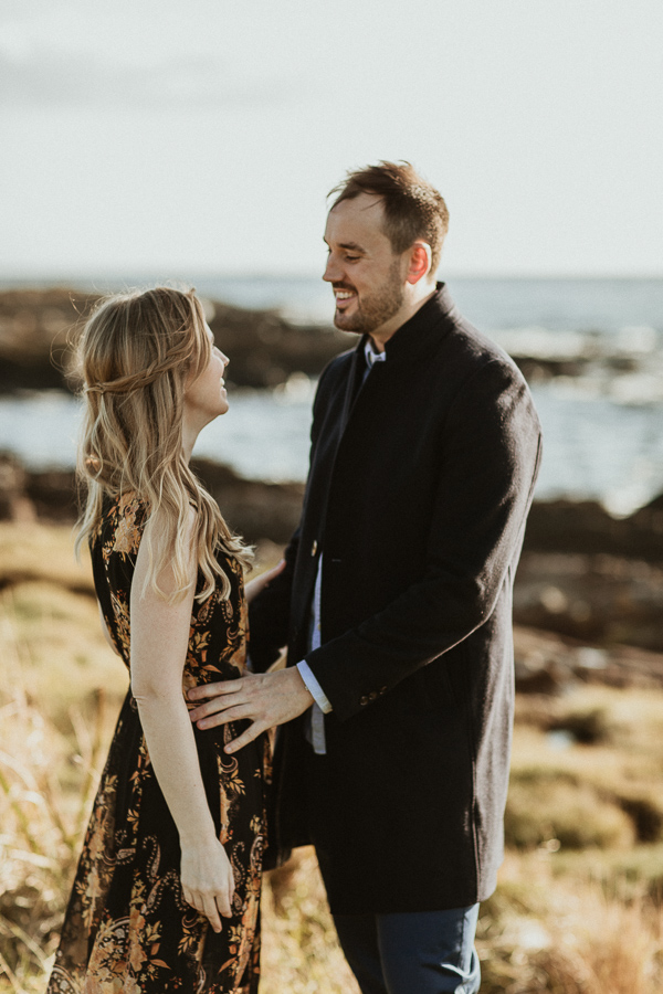 A couple on a beach having their engagement photos taken