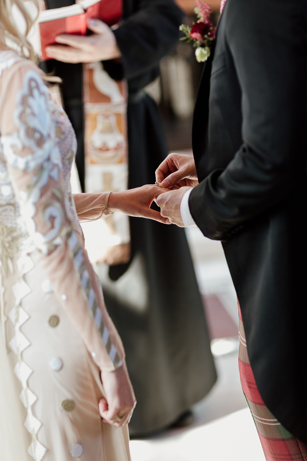 groom putting ring on brides finger scotland
