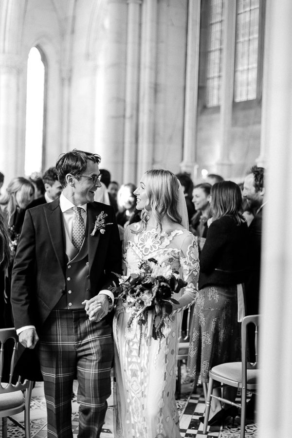 bride and groom looking at each other walking from ceremony
