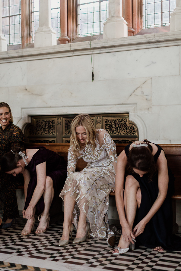 bride with bridesmates putting their shoes on