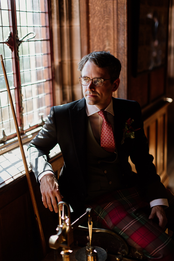 groom looking through a window at pool room bute