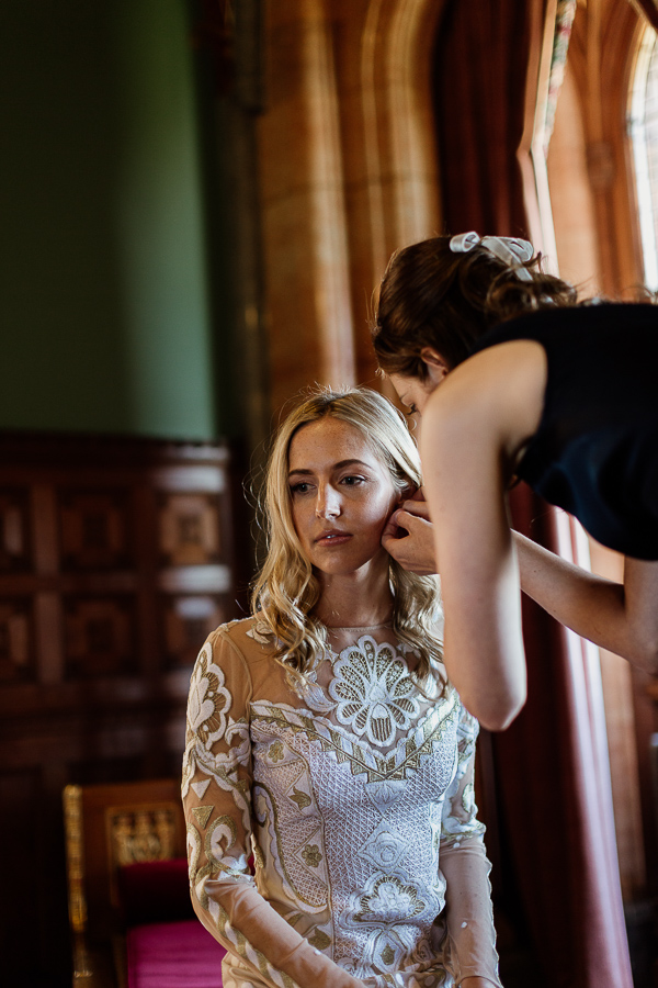 bridesmate putting earling on bride