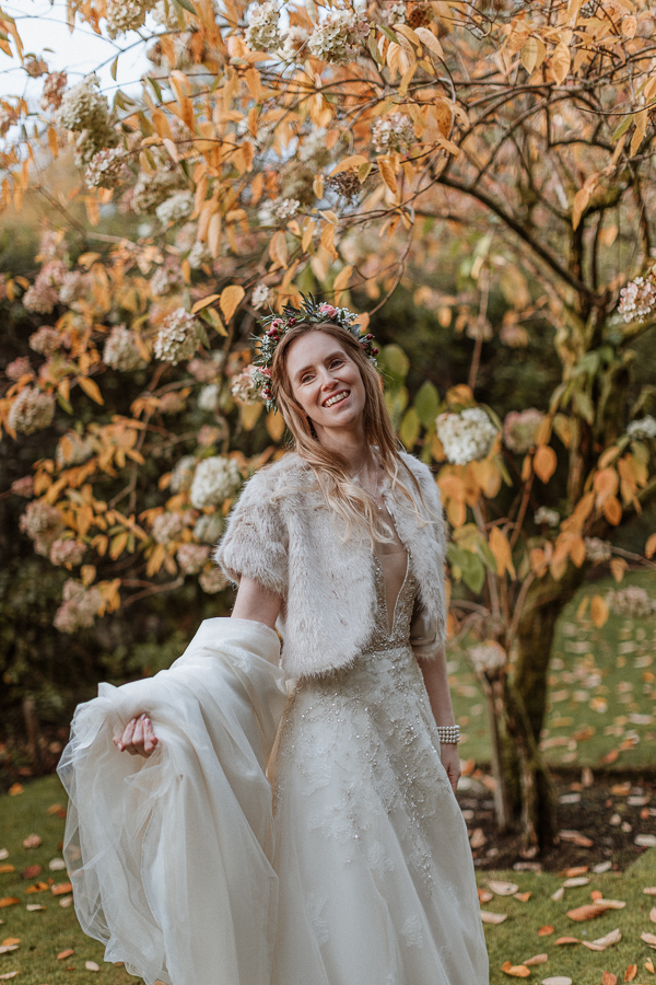 bride holding her dress by the tree at Glenapp Castle Scotland 