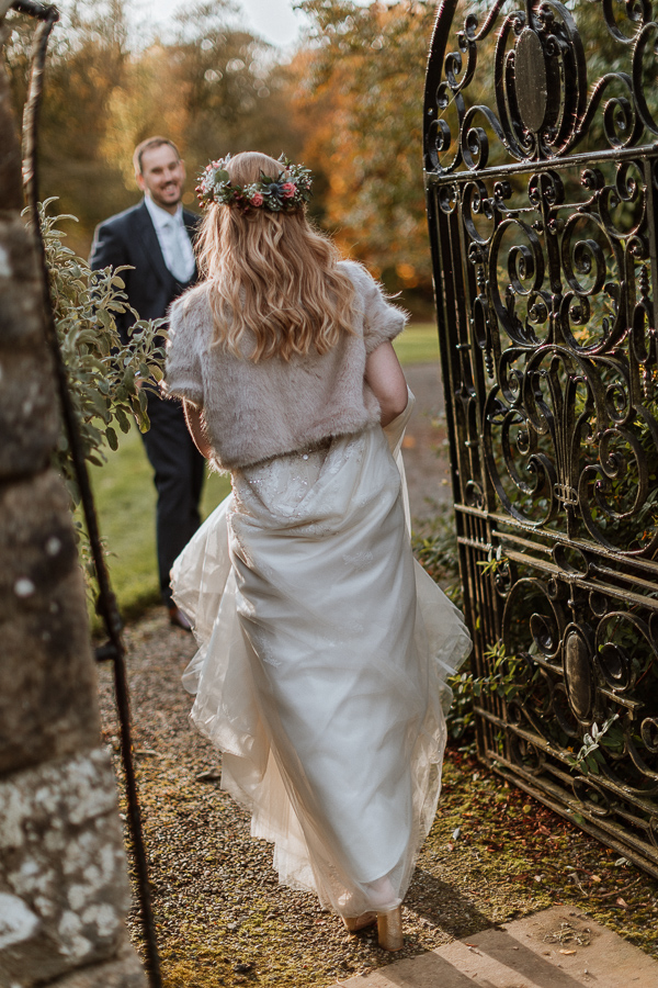 bride waking through a gate of Glenapp Estate
