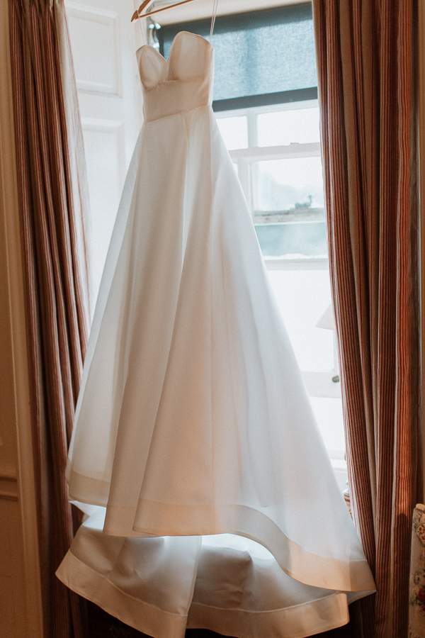 wedding dress hanging on a window at dumfries house