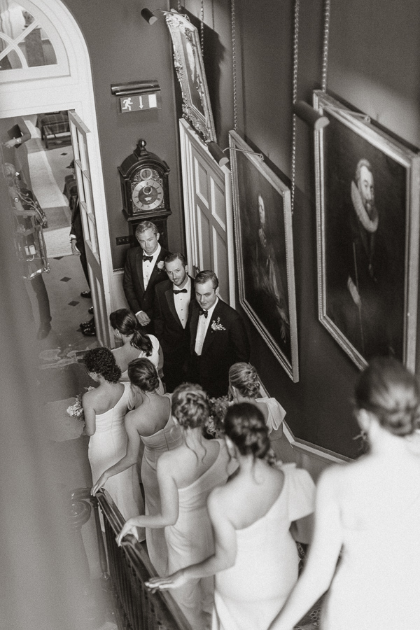 groom looking at bridesmates walking down